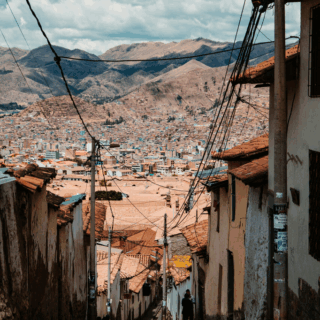 callejón_empedrado_con_personas_hacia_ciudad_montañosa-cobblestone_alley_with_people_towards_mountain_city