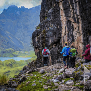 grupo_de_excursionistas_en_sendero_montañoso_con_lago-group_of_hikers_on_mountain_trail_with_lake