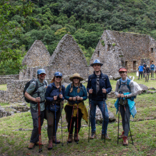 grupo_de_excursionistas_frente_a_ruinas_incas_en_montaña.-group_of_hikers_in_front_of_inca_ruins_on_mountain.