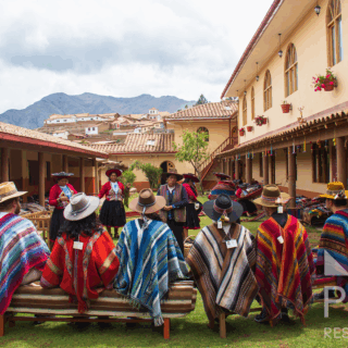 grupo_de_personas_con_ponchos_coloridos_en_patio_andino-group_of_people_with_colorful_ponchos_in_andean_patio