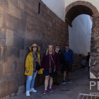 grupo_de_personas_junto_a_muro_inca_en_callejón-group_of_people_next_to_inca_wall_in_alleyway
