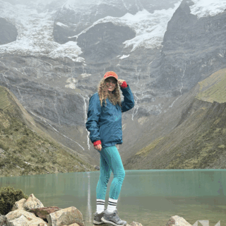 mujer_sonriente_frente_a_lago_y_montañas_nevadas-smiling_woman_in_front_of_lake_and_snowy_mountains