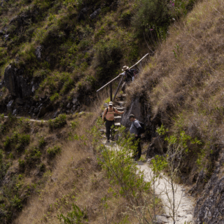senderistas_en_sendero_de_montaña_con_barandilla-hikers_on_mountain_path_with_railing