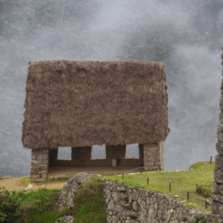 turista_junto_edificio_techo_paja_machu_picchu-tourist_next_to_thatched_roof_building_machu_picchu
