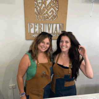 amigas_con_delantales_frente_a_letrero_peruano-friends_with_aprons_in_front_of_peruvian_sign