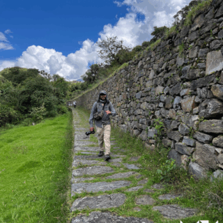 hombre_con_cámara_camina_por_sendero_de_piedra-man_with_camera_walks_on_stone_path