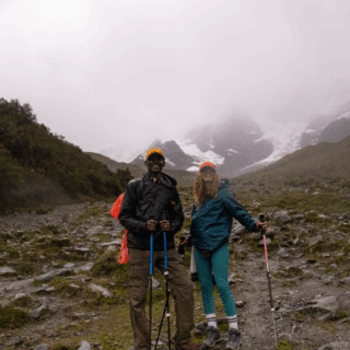 pareja_en_sendero_rocoso_con_montañas_nevadas-couple_on_rocky_trail_with_snowy_mountains